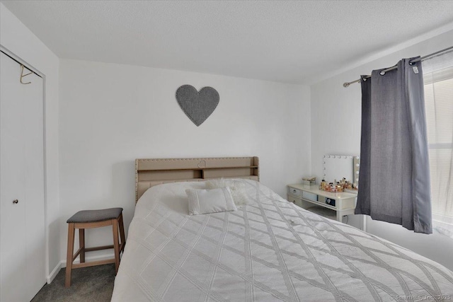 carpeted bedroom with a closet and a textured ceiling