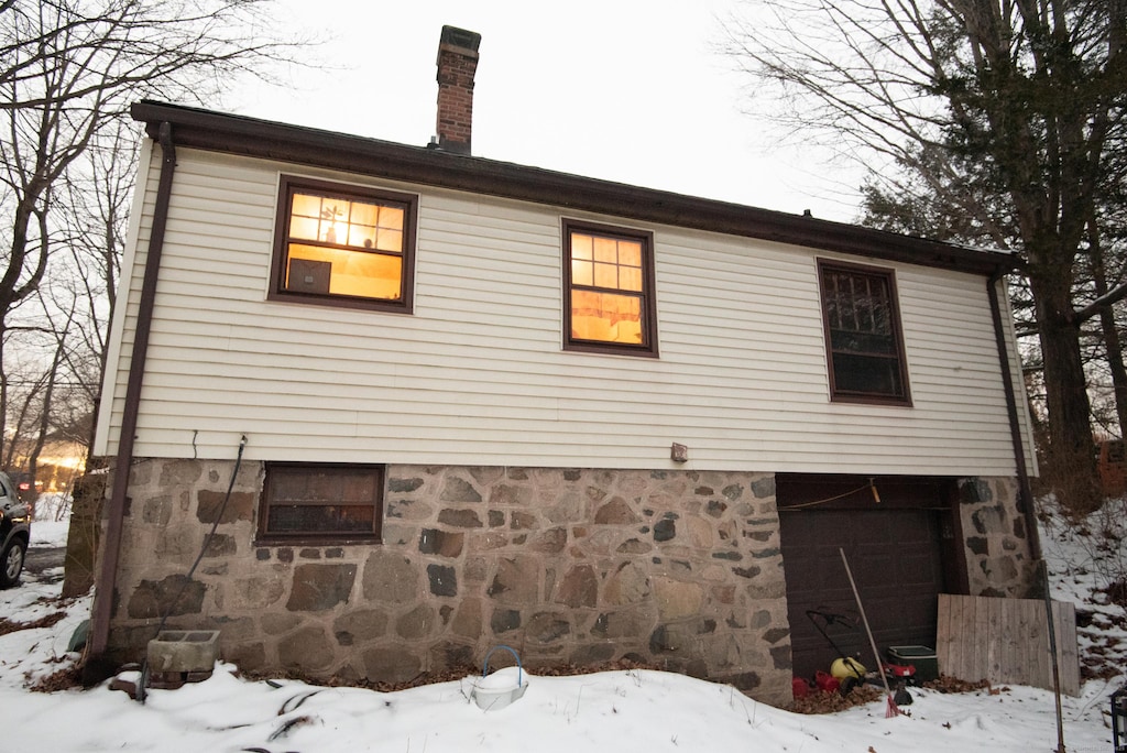 view of snow covered exterior featuring a garage