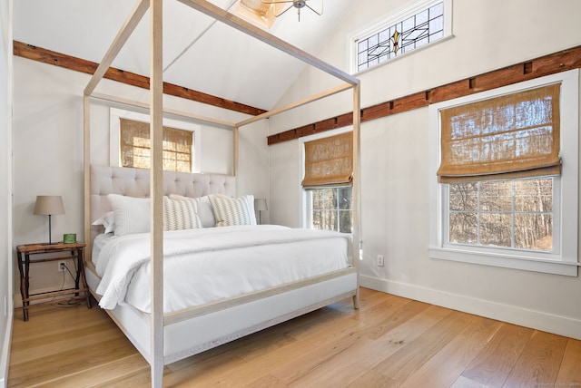 bedroom with multiple windows, light hardwood / wood-style flooring, and high vaulted ceiling