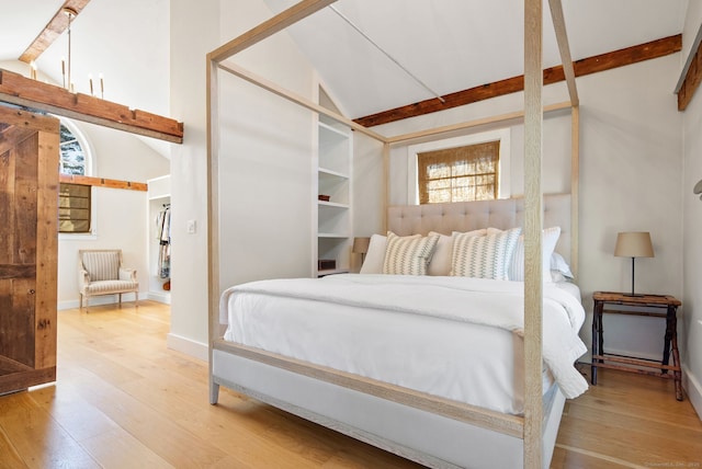 bedroom featuring hardwood / wood-style flooring and lofted ceiling with beams