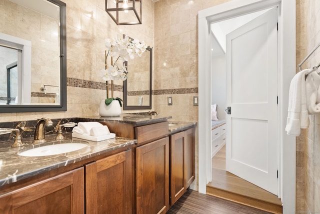 bathroom featuring hardwood / wood-style flooring, vanity, and tile walls