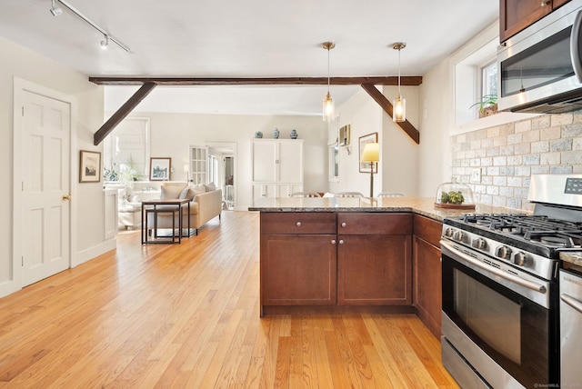 kitchen with light hardwood / wood-style flooring, appliances with stainless steel finishes, hanging light fixtures, light stone countertops, and decorative backsplash