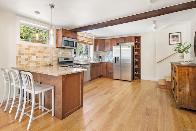 kitchen with appliances with stainless steel finishes, pendant lighting, backsplash, kitchen peninsula, and beam ceiling