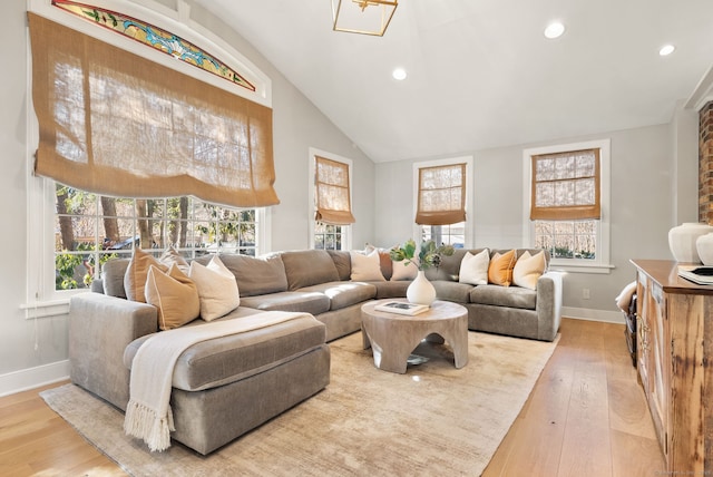 living room featuring hardwood / wood-style floors, high vaulted ceiling, and a healthy amount of sunlight