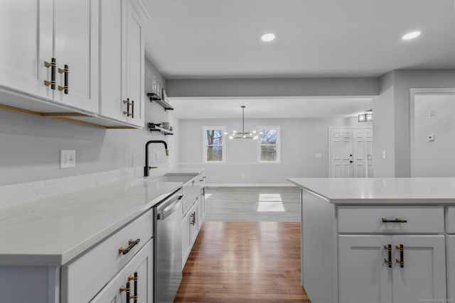 kitchen with dishwasher, a sink, wood finished floors, and recessed lighting