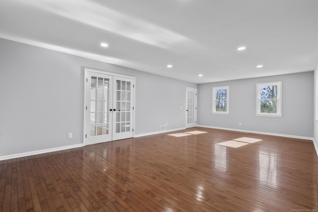 unfurnished living room featuring hardwood / wood-style flooring, recessed lighting, baseboards, and french doors