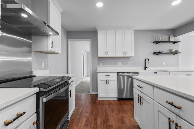 kitchen with white cabinets, electric stove, wall chimney exhaust hood, light countertops, and stainless steel dishwasher