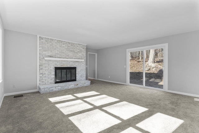 unfurnished living room with baseboards, a fireplace, visible vents, and carpet flooring