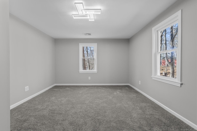 carpeted empty room with baseboards and visible vents