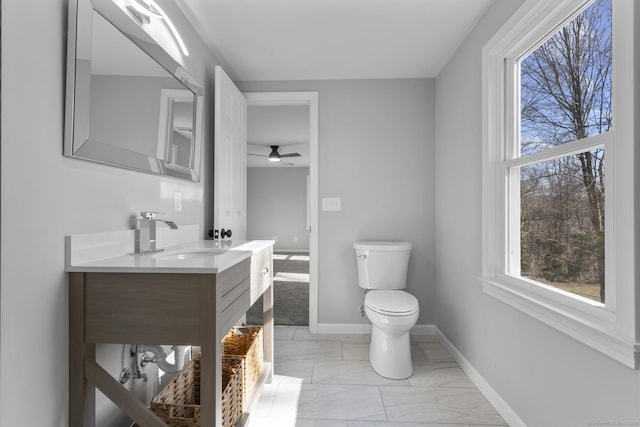 bathroom with marble finish floor, baseboards, vanity, and toilet