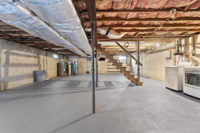 unfinished below grade area featuring separate washer and dryer, stairway, electric water heater, and electric panel