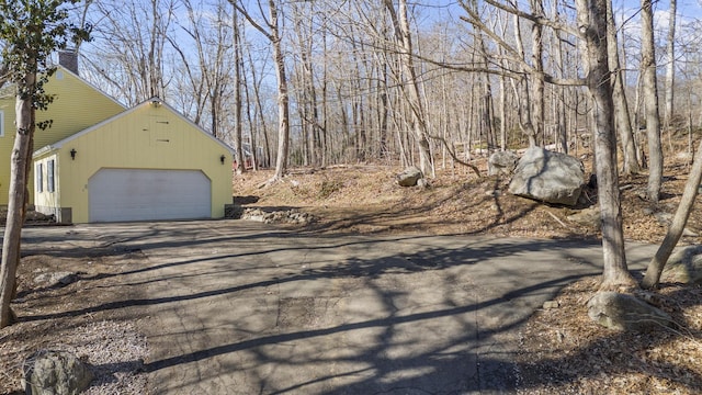 view of side of home featuring driveway and a garage