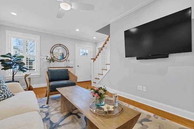 living room with crown molding, light hardwood / wood-style flooring, and ceiling fan