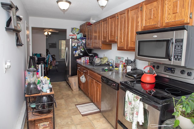 kitchen featuring ceiling fan, stainless steel appliances, and sink