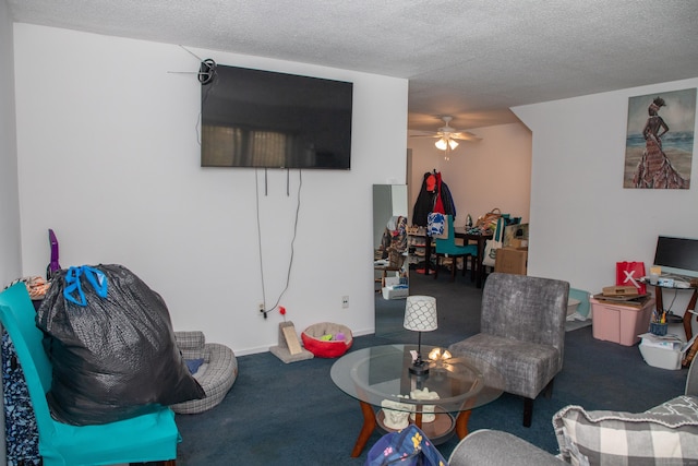 living room with ceiling fan, carpet floors, and a textured ceiling