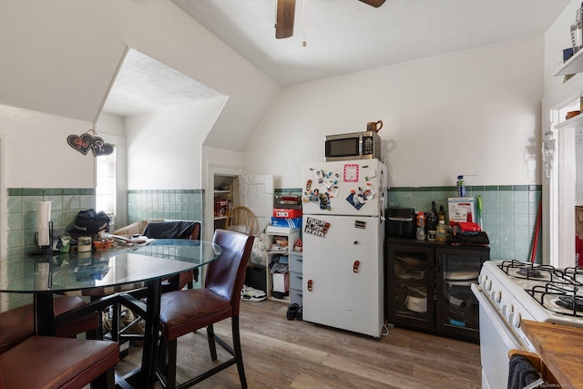 kitchen with wood-type flooring, tile walls, ceiling fan, and white appliances