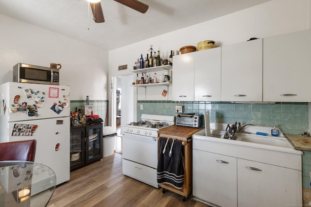 kitchen featuring sink, white appliances, light hardwood / wood-style flooring, ceiling fan, and white cabinets