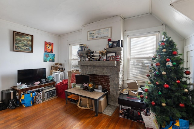 living room with hardwood / wood-style flooring, vaulted ceiling, and crown molding