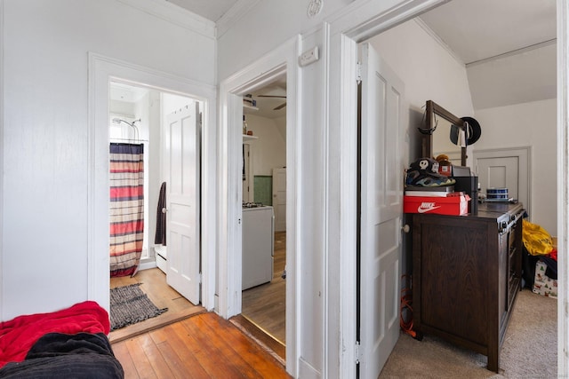 corridor featuring ornamental molding, washer / dryer, and hardwood / wood-style floors