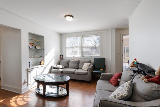 living room with dark hardwood / wood-style flooring and built in shelves