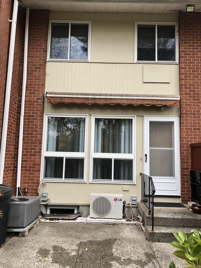 back of house with cooling unit and ac unit