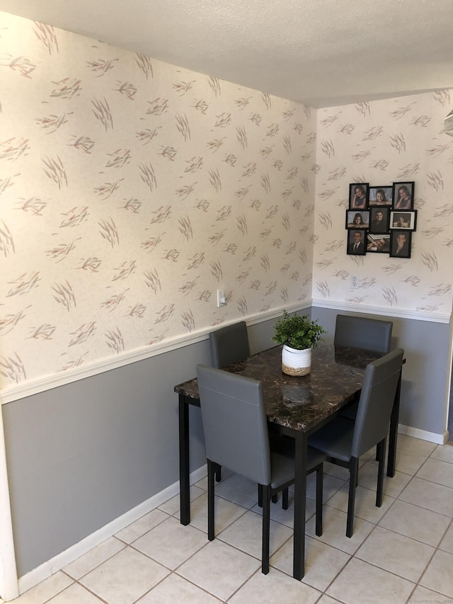 dining area featuring a textured ceiling and light tile patterned floors