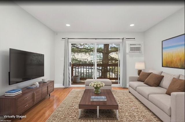 living room featuring light hardwood / wood-style flooring and a wall unit AC