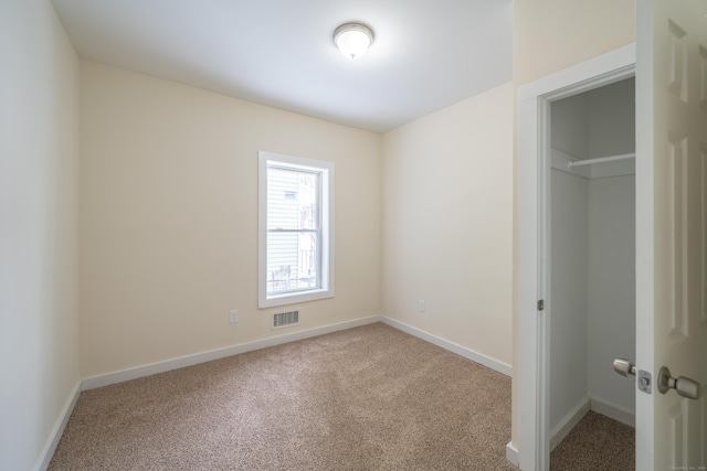 unfurnished bedroom featuring light carpet, a spacious closet, and a closet