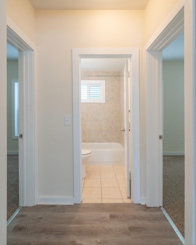 corridor with light hardwood / wood-style floors