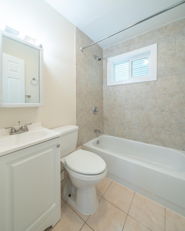 full bathroom with tile patterned flooring, vanity, tiled shower / bath combo, and toilet