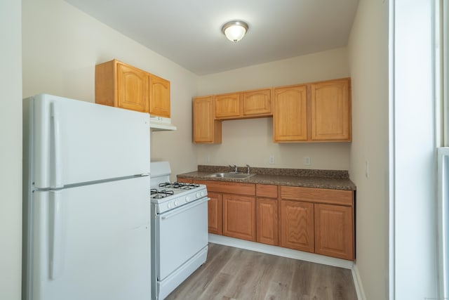 kitchen featuring sink, white appliances, and light hardwood / wood-style floors