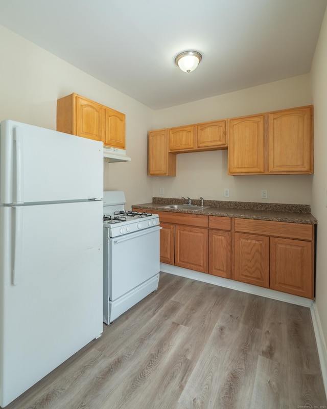 kitchen featuring white appliances, light hardwood / wood-style floors, and sink