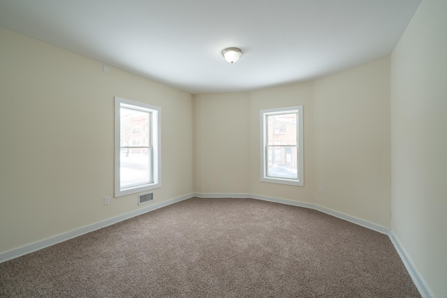 empty room with plenty of natural light and carpet floors