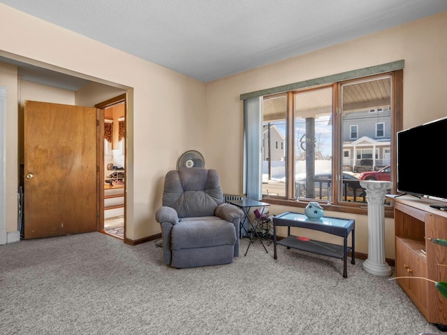 sitting room with carpet, decorative columns, and baseboards