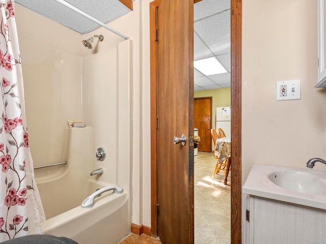 bathroom featuring shower / tub combo, a drop ceiling, and a sink