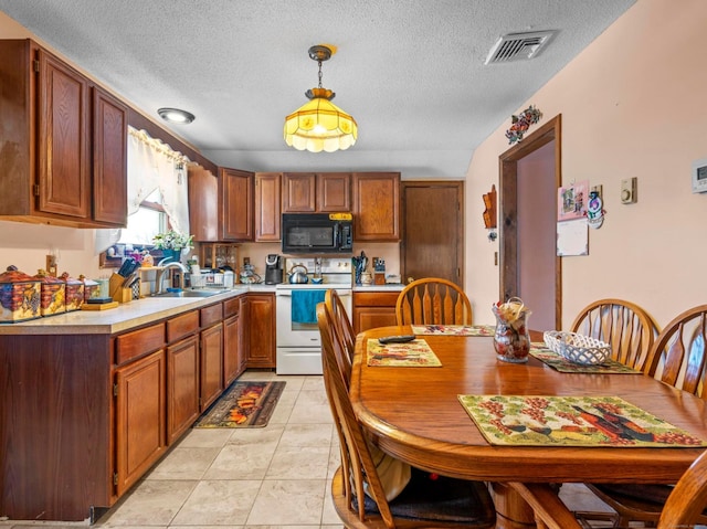 kitchen with black microwave, white electric range, visible vents, hanging light fixtures, and light countertops