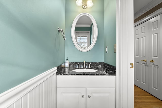 bathroom with crown molding, hardwood / wood-style floors, and vanity