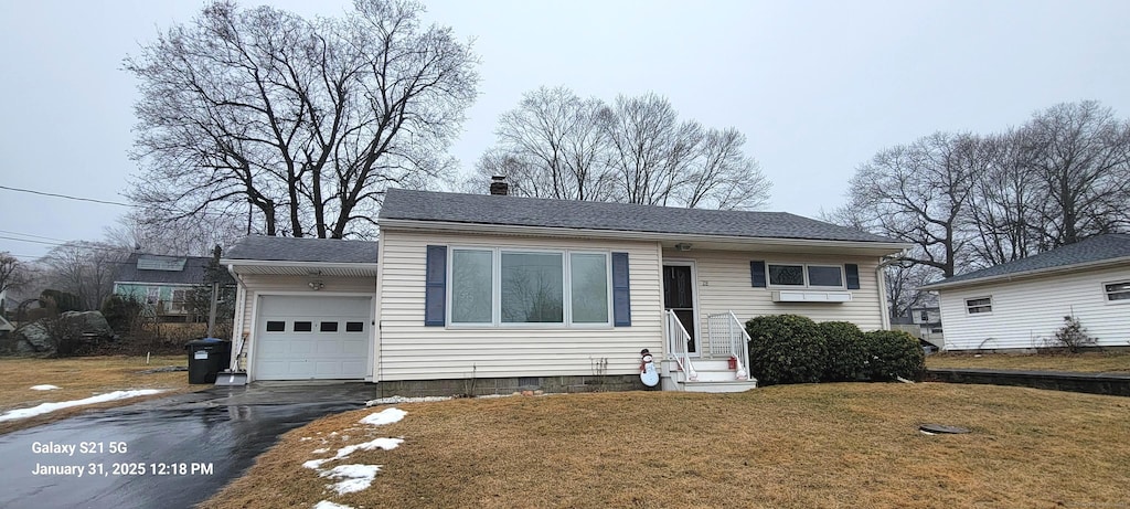 view of front of house with a garage and a front lawn