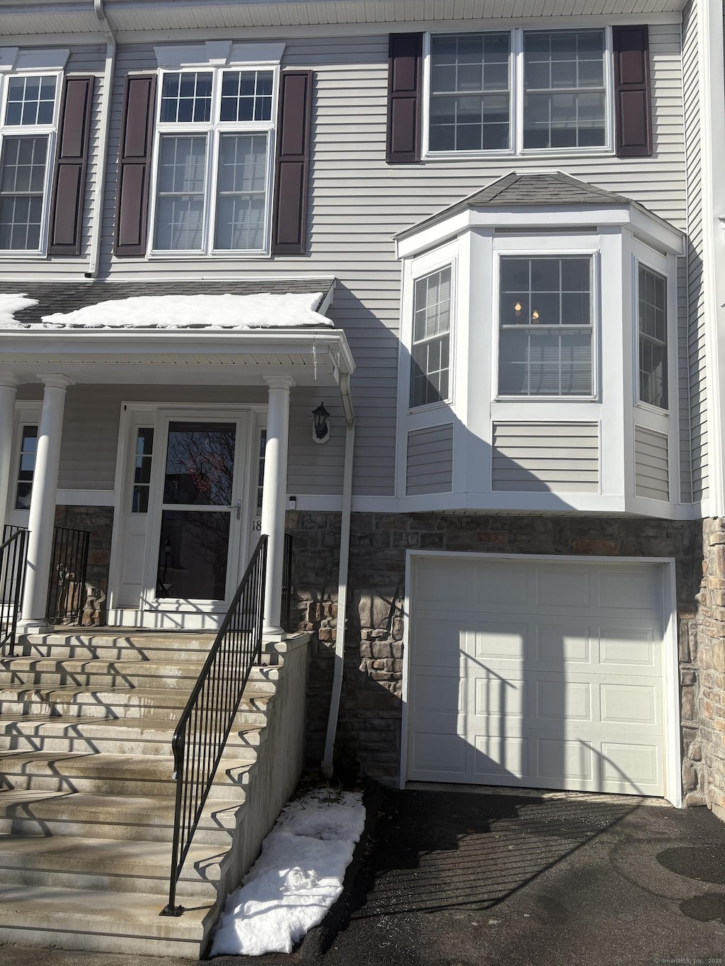 entrance to property featuring a garage and a porch