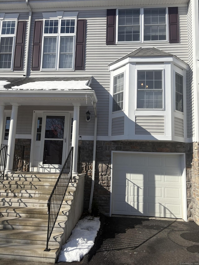 entrance to property featuring a garage and a porch