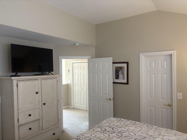 bedroom featuring light colored carpet and vaulted ceiling