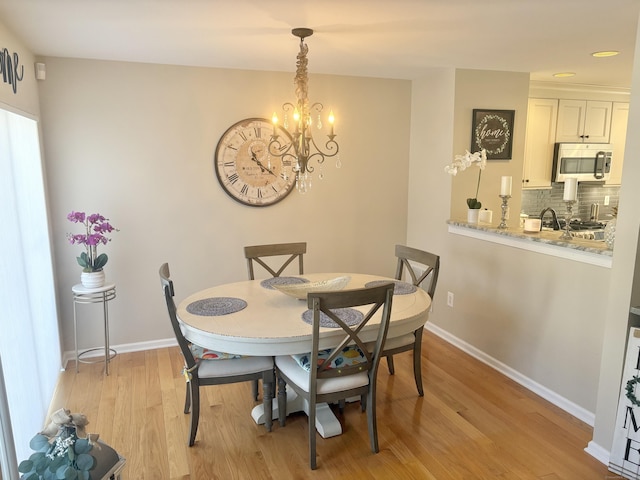 dining room with a notable chandelier and light wood-type flooring