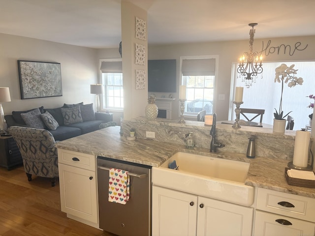 kitchen with white cabinetry, decorative light fixtures, dishwasher, and sink