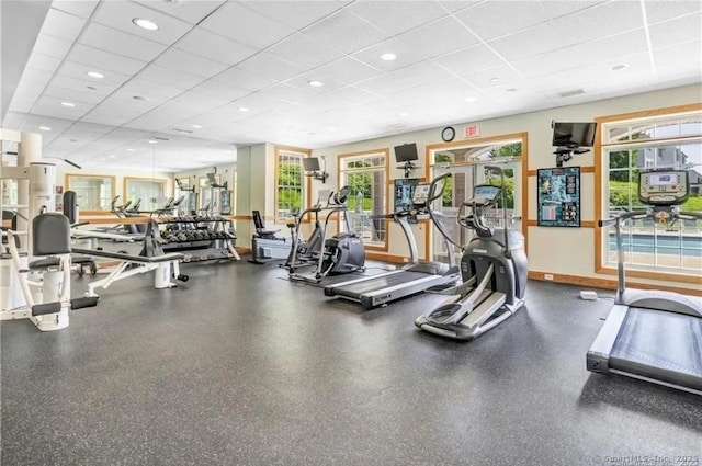 workout area with plenty of natural light and a drop ceiling