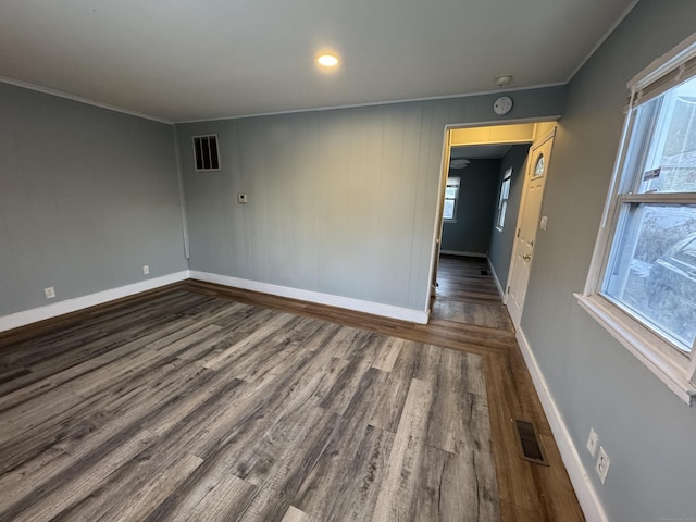 unfurnished room with crown molding and dark wood-type flooring