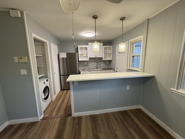 kitchen featuring pendant lighting, washer / clothes dryer, stainless steel fridge, white cabinets, and kitchen peninsula