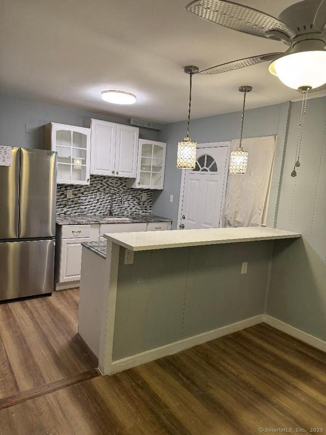 kitchen with white cabinetry, dark hardwood / wood-style floors, stainless steel fridge, and kitchen peninsula