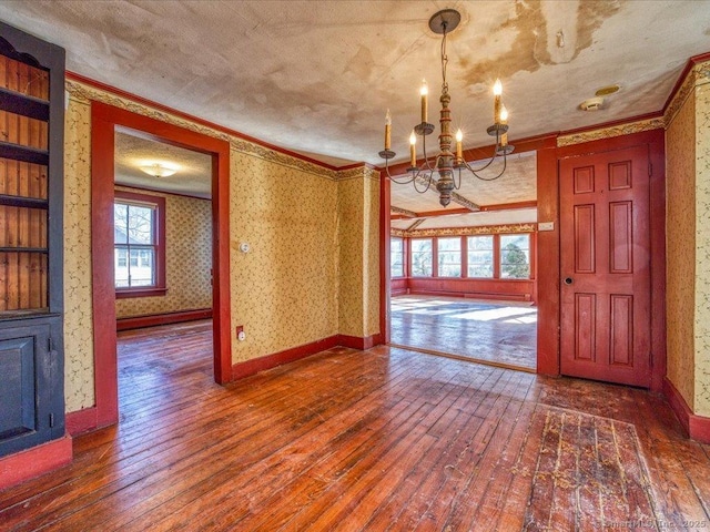 unfurnished dining area featuring ornamental molding, dark hardwood / wood-style floors, a chandelier, and baseboard heating