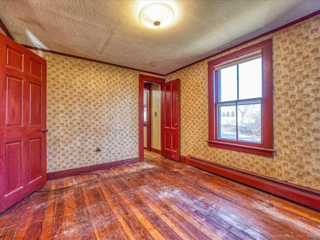 interior space featuring hardwood / wood-style floors, a baseboard radiator, ornamental molding, and a textured ceiling