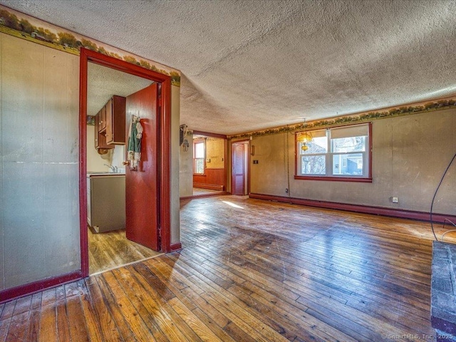 empty room with hardwood / wood-style flooring and a textured ceiling